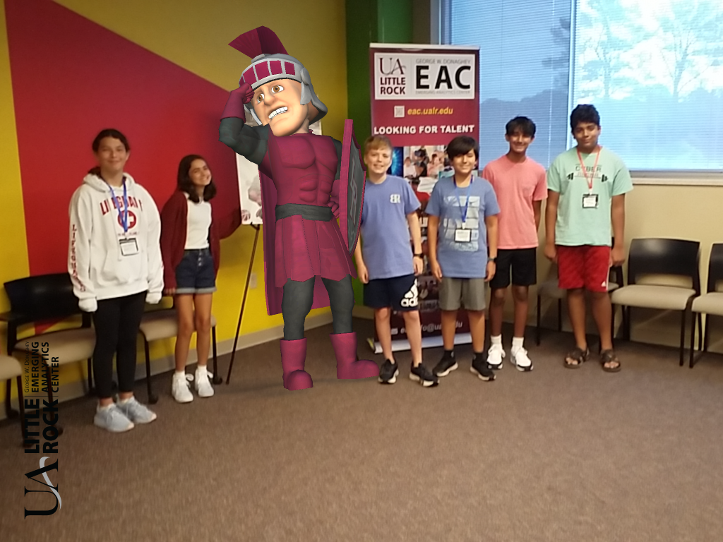 A group of smiling students standing beside a posing Trojan man mascot.